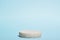 Minimalistic scene of a lying stone on a light blue background. Podium for the presentation of goods and cosmetics. A