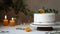 Minimalistic single tier wedding cake with white icing and sliced orange and eucalyptus decoration. Close up, background, top view