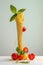 A minimalistic still life concept: A neatly arranged stack of spaghetti adorned with fresh tomatoes and basil on grey