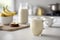 A minimalistic still life of a cup of banana milk coffee on a white table