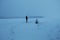 Minimalistic view of a person in the cold snowy field at dusk