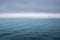 Minimalistic view of the sea with ripples under a dark gray sky