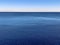 Minimalistic water surface with blue seascape horizon and clear gradient sky