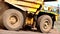 Mining dump truck close up. Large wheels of a mining dump truck. A large modern dump truck travels through the quarry