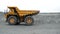 Mining dump truck is moving on a quarry road. Close-up.