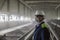 Mining engineer in white helmet and respirator inspects dusty dirty workshop