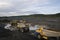 Mining trucks are queuing, in the background a wheel loader is loading mountain soil into the bodies of these trucks