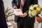 Minister hoding family book written in german stammbuch in front of Wedding flowers held by bride closeup. yellow roses