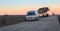 Minivan moves on the road against the background of mountains at sunset