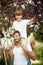 Minor boy and young adult father picking cherries, looking at camera, smiling