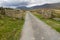 Minor road leading into valley surrounded by mountains.