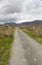 Minor road leading into valley surrounded by mountains.