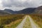 Minor road leading into valley surrounded by mountains.