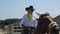 Minsk, Belarus - 19 July 2019: Beautiful young girl in a cowboy costume with glasses rides a horse on a ranch in the