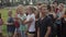 Minsk, Belarus - 19 July 2019: A group of beautiful boys and girls teenagers stands on a green lawn on a summer day