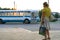 Minsk, Belarus - 31th of July 2010: A woman on a bus stop in minsk, white with blue bus is approaching