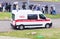 MINSK, BELARUS - JULY 3, 2018: A modern ambulance car is in the city, there are people with umbrellas, rain