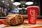 Minsk, Belarus, March 27, 2018: Sandwich with KFC logo and paper cup with Coca-Cola logo on table in KFC Restaurant