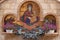 Minsk, Belarus. - May, 2019. Close-up of fountain with flowers and mosaical image of Mary Virgin with Jesus Christ