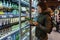 MINSK, BELARUS - October 4, 2019: Woman buys alcohol in grocery store. Young woman reading ingredients, declaration or expiration