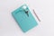 Mint color notebook with home keys and a pen concept of planing a house buying, mortgage, debt or property loan or gift
