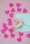 Mint envelope with a pink rose flower and heart shaped confetti