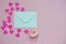 Mint envelope with a pink rose flower and heart shaped confetti