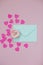 Mint envelope with a pink rose flower and heart shaped confetti