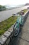 Mint green retro parked bicycle near lake and road