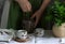 Mint tea in a vintage Chinese tea set, a woman in a linen dress and an apron, and a bouquet of mint in a jug