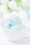 Mint or tiffany color macaron or macaroon dessert with vanilla cream in white cup. Copy space