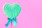 Mint and white spiral heart lollipop isolated on pink backgroun