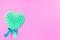 Mint and white spiral heart lollipop isolated on pink backgroun