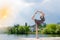 Miracle dancer: image of wonderfully dancing blond girl in light dress at water lake on lighting rays sunshine blue sky outdoors