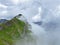 Miraculous low clouds and a mystical fog of the mountain range First and in the Schwyz Alps mountain massif, Oberiberg