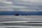 Mirages on the water? Silhouettes of an off-road vehicle and people in the Salar de Uyuni flooded after the rains, Bolivia. Clouds