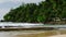 Mirissa beach lagoon Sri Lanka with tourists surfing, waves crash on rocky shore, tropical palms, coastal vacation spot