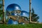 Mirror art object by sculptor Ken Kelleher Inner Child. Big baby heads with smiling faces in Public landscape city park Krasnodar