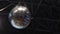 The mirror ball is spinning and shining. The disco ball reflected playground and stands.