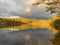 Mirror calm lake in the woods bathing in beutiful evening light