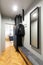 Mirror and clothes on rack in grey anteroom interior with light