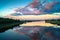 Mirror glossy surface of the Volga river reflects dramatic sunset sky. City of Tver, Russia.