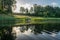 Mirror image on the lake, green forest reflected on the surface of the lake, boat on the shore of the lake, beauty in nature