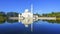 Mirror reflection of beautiful white floating mosque in a lake d
