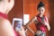 Mirror selfie confident Asian woman feeling pretty good in her body taking photo with mobile phone