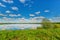 Mirror smooth of pond beneath blue cloudy sky in summer day