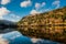 Mirror View over Upper Lake in Glendalough Scenic Park, a lot of hills and trees, sun and clouds