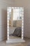 Mirror whith white frame and light bulbs in interior flat