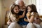 Mirthful children hugging their grandpa stock photo