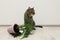 Mischievous cat near overturned houseplant on floor indoors